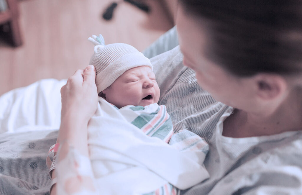 a mom hold a baby that has just been been born in a hospital