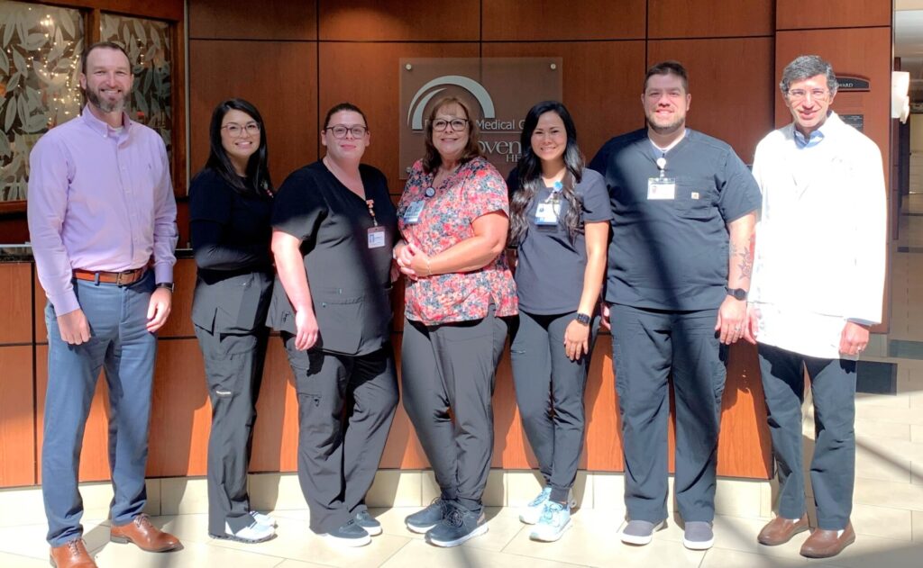 Team members standing in front of information desk.