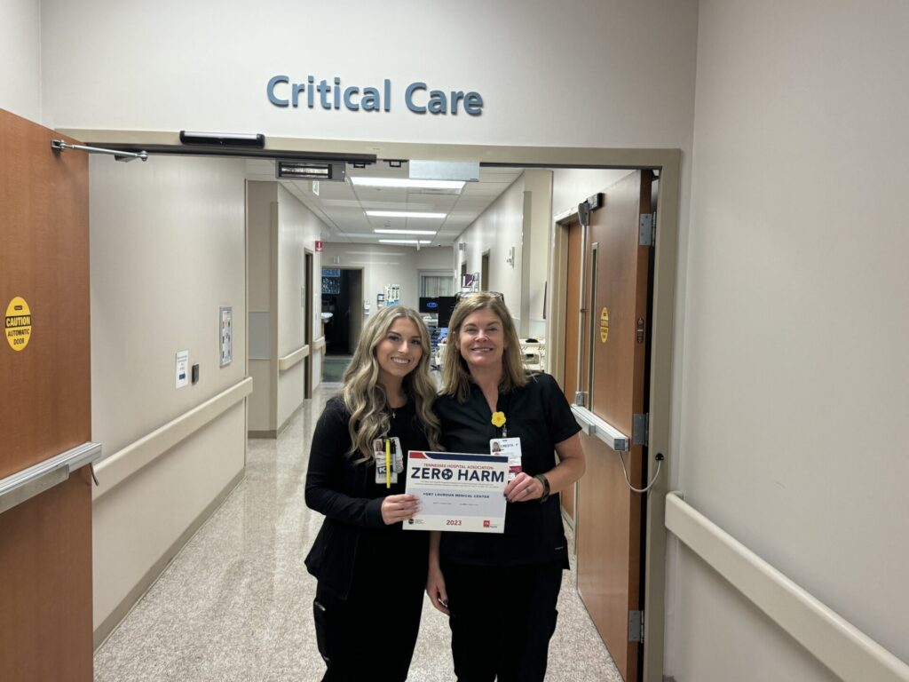 Nurses holding zero harm award sign.