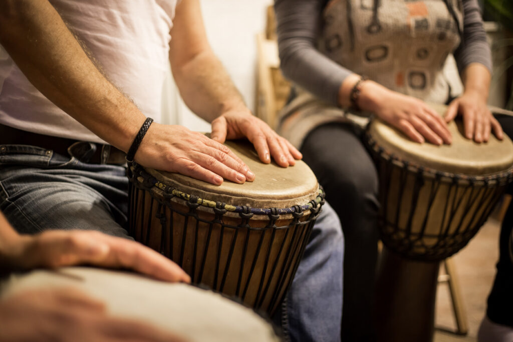 Members of a drumming circle with 
 hands on African drums 