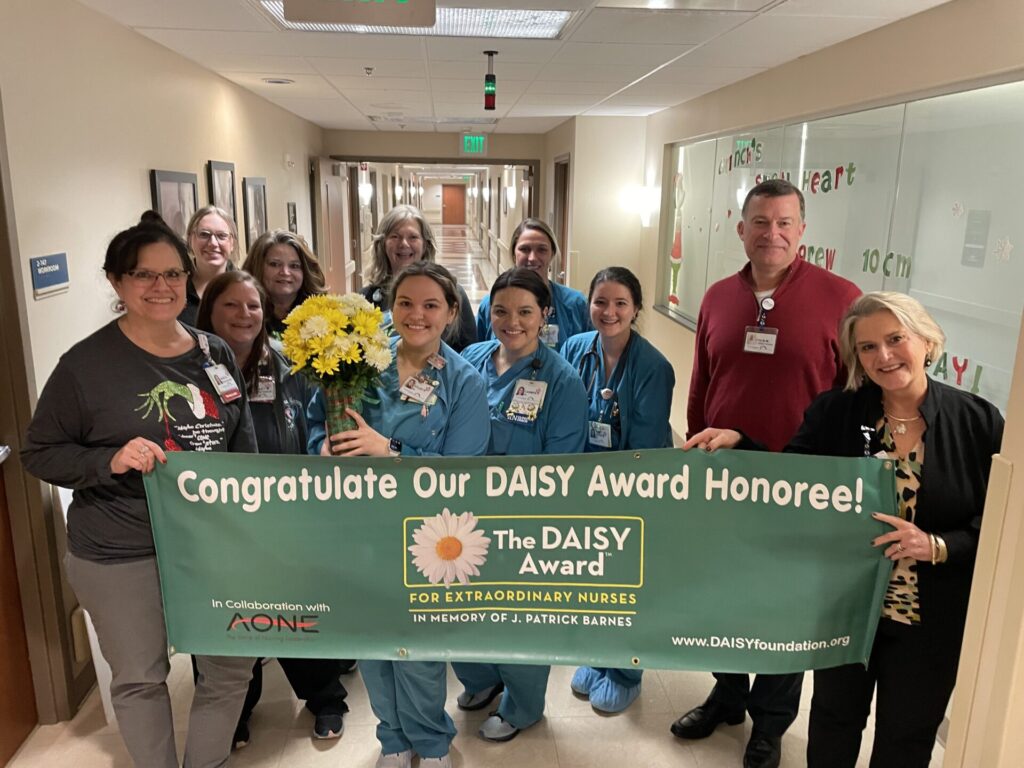 Group of people with DAISY Award banner.