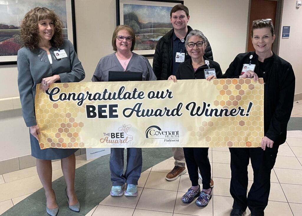 Group of people holding BEE Award banner.