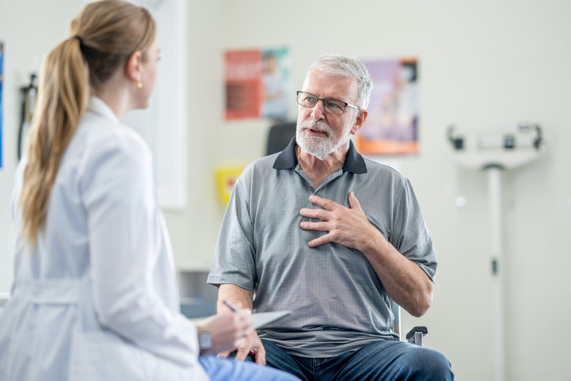 A senior male patient sits with his female doctor during a medical appointment.