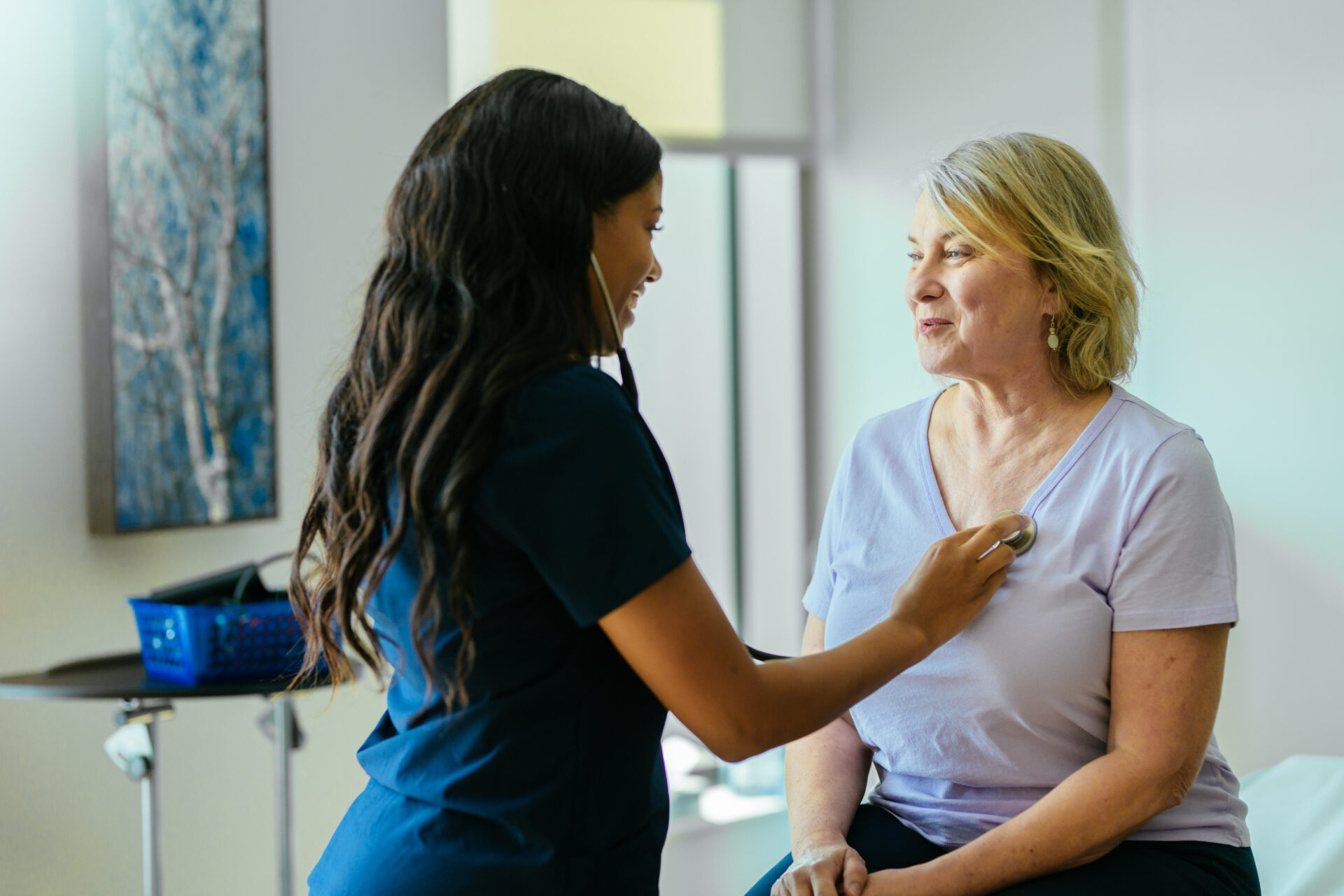 A doctor listens to her patient's heartbeat using a stethoscope.